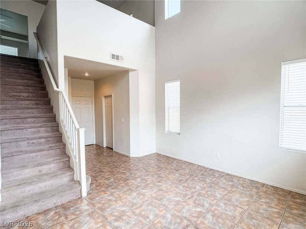 228 Positive Point Street Henderson, NV 89012 - Photo 8 of 27 A spacious living area with soaring ceilings and a graceful staircase creates an inviting atmosphere.