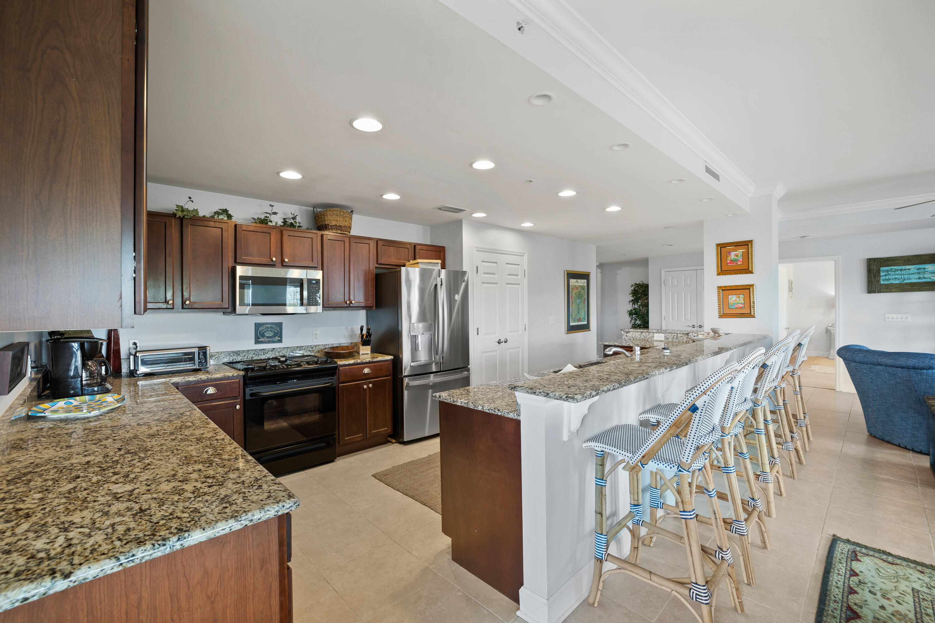 1732 West County Highway 30A, Unit 403R Santa Rosa Beach, FL 32459 - Photo 10 of 57 a kitchen with stainless steel appliances granite countertop a stove top oven a sink dishwasher and a refrigerator with wooden floor