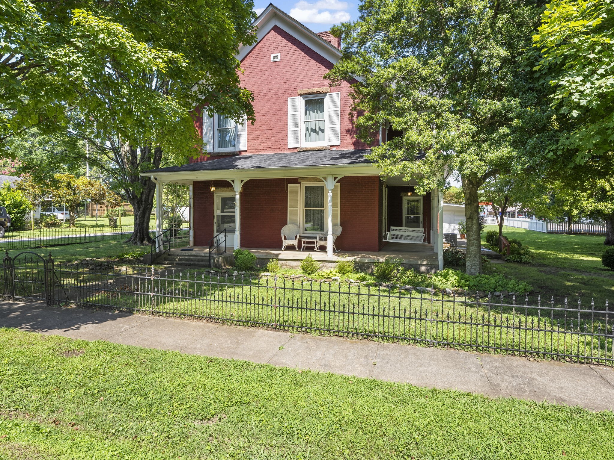 a view of a house with a big yard plants and large trees