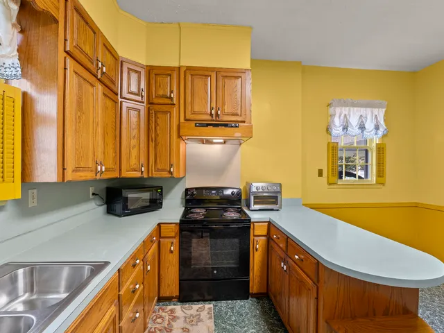 a kitchen with stainless steel appliances granite countertop a sink a stove and a refrigerator