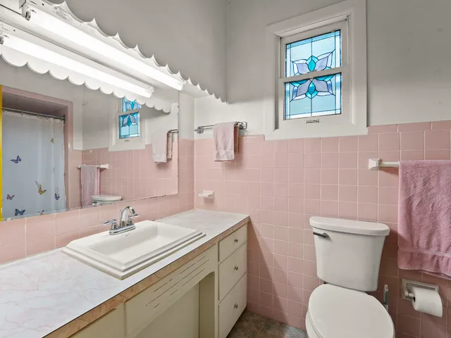 a bedroom with a bed a fireplace and dresser