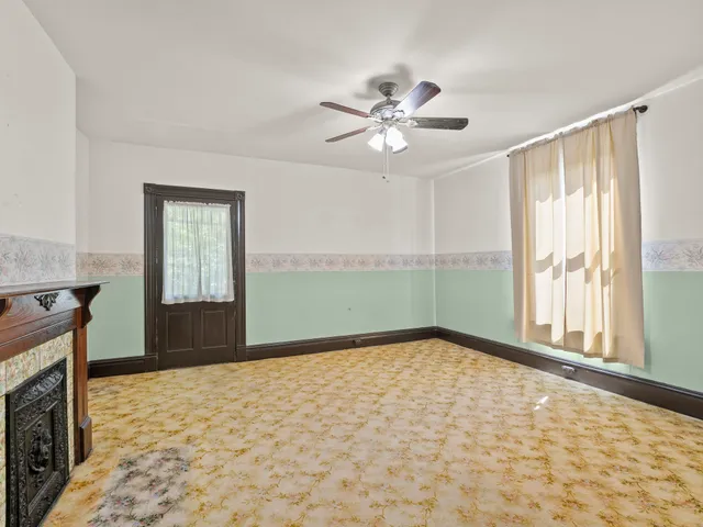 a view of an empty room with a fireplace and a window