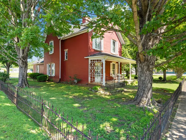 a front view of a house with a yard and trees
