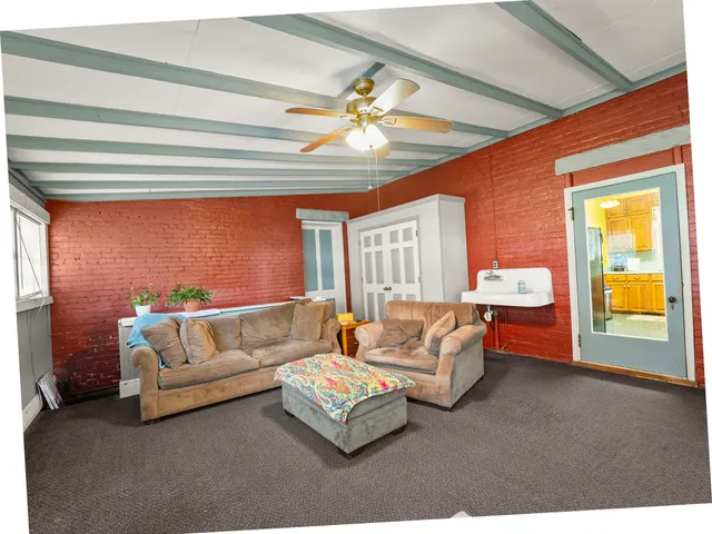 a living room with furniture a flat screen tv and a chandelier