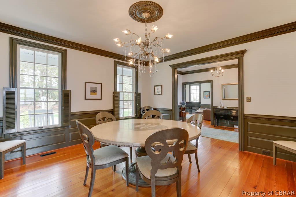 3459 Stonewall Road Hayes, VA 23072 - Photo 16 of 50 Dining area featuring ornamental molding, light hardwood / wood-style floors, and a chandelier