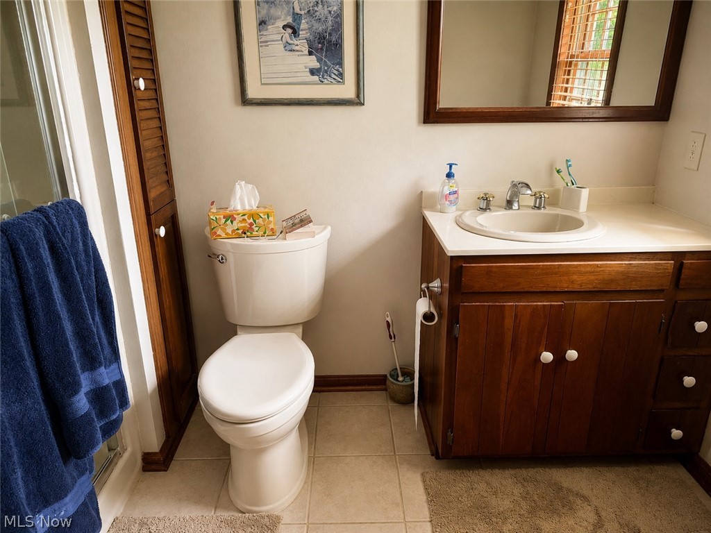 6155 Gibson Road Canfield, OH 44406 - Photo 30 of 43 Bathroom featuring a white toilet, wood-finish vanity with a light-toned countertop and integrated sink, and a framed mirror