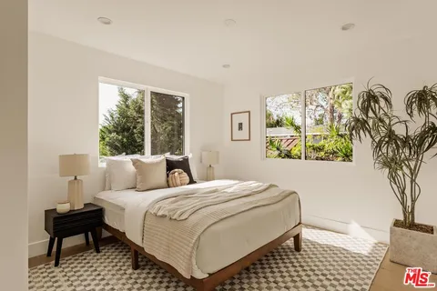 a bedroom with a bed and a painting on the wall