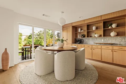 a living room with kitchen island granite countertop furniture a large window and stainless steel appliances