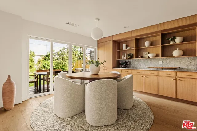 a living room with kitchen island granite countertop furniture a large window and stainless steel appliances