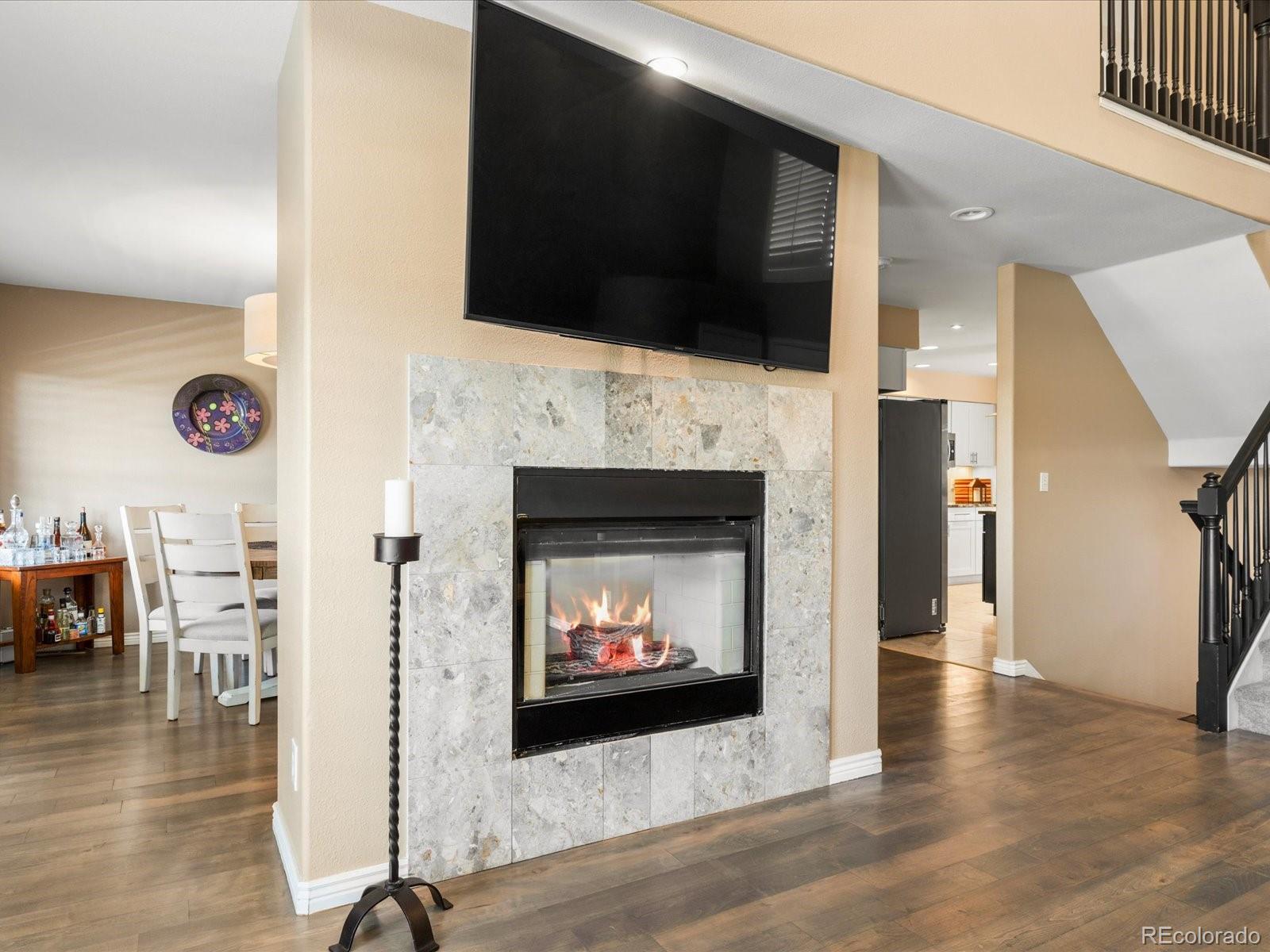 9323 Notts Court Lone Tree, CO 80124 - Photo 11 of 45 a living room with a fireplace a flat screen tv and a table