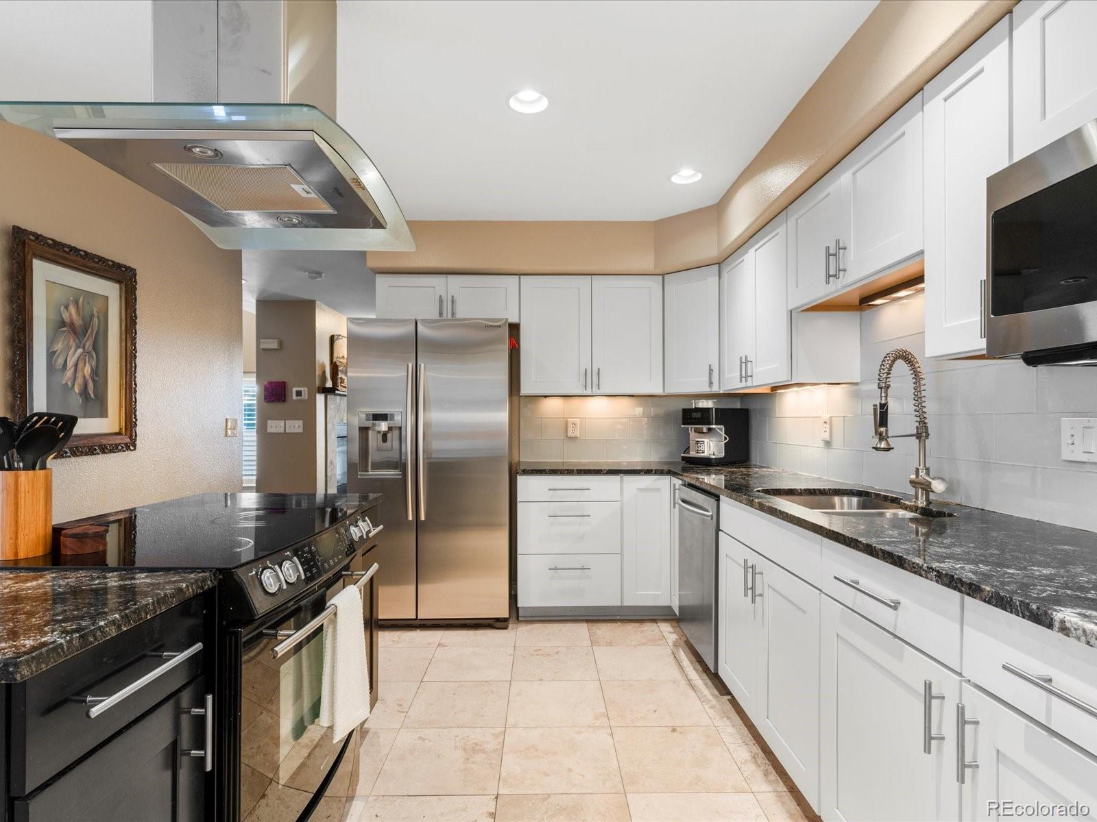 9323 Notts Court Lone Tree, CO 80124 - Photo 15 of 45 a kitchen with stainless steel appliances granite countertop a sink stove and refrigerator