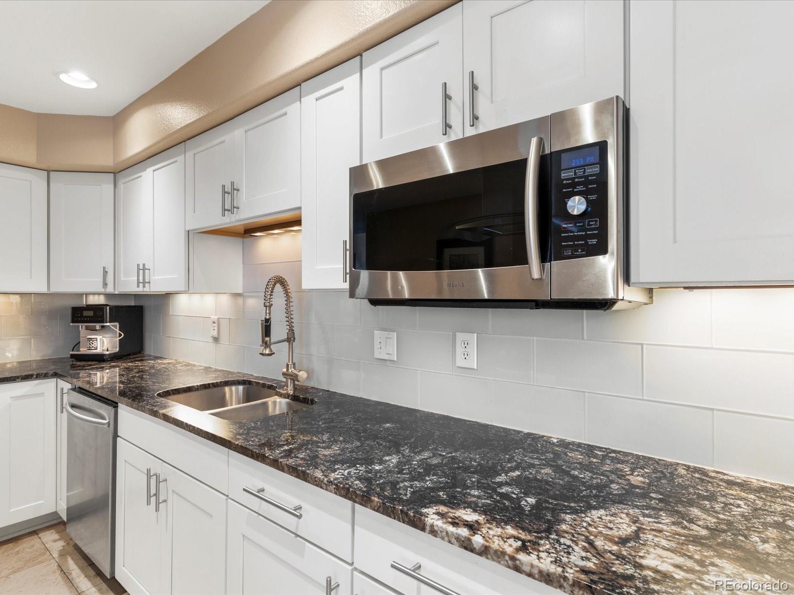 9323 Notts Court Lone Tree, CO 80124 - Photo 16 of 45 a kitchen with stainless steel appliances granite countertop a sink and a microwave