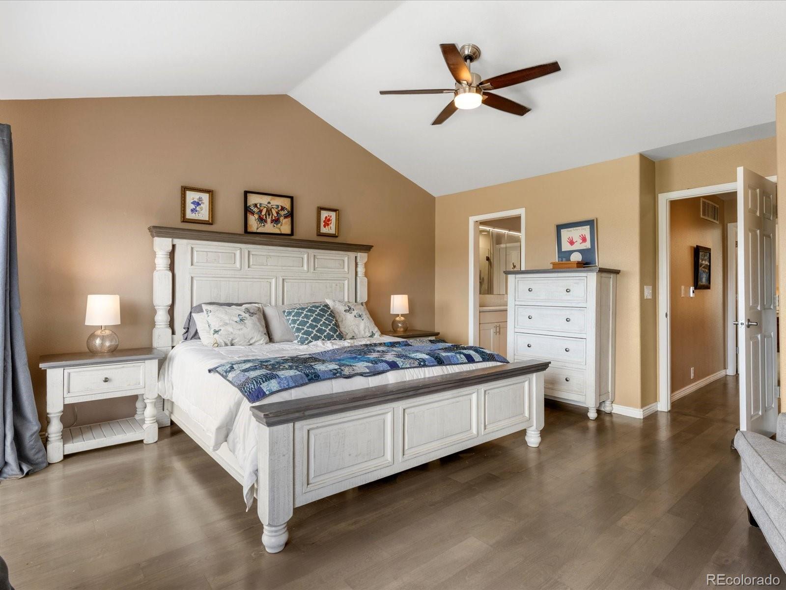 9323 Notts Court Lone Tree, CO 80124 - Photo 22 of 45 a bedroom with a large bed and a chandelier
