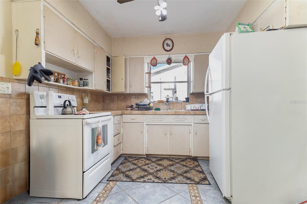 1638 East Main Street Lakeland, FL 33801 - Photo 7 of 16 a kitchen with a white stove top oven and white countertops with cabinets