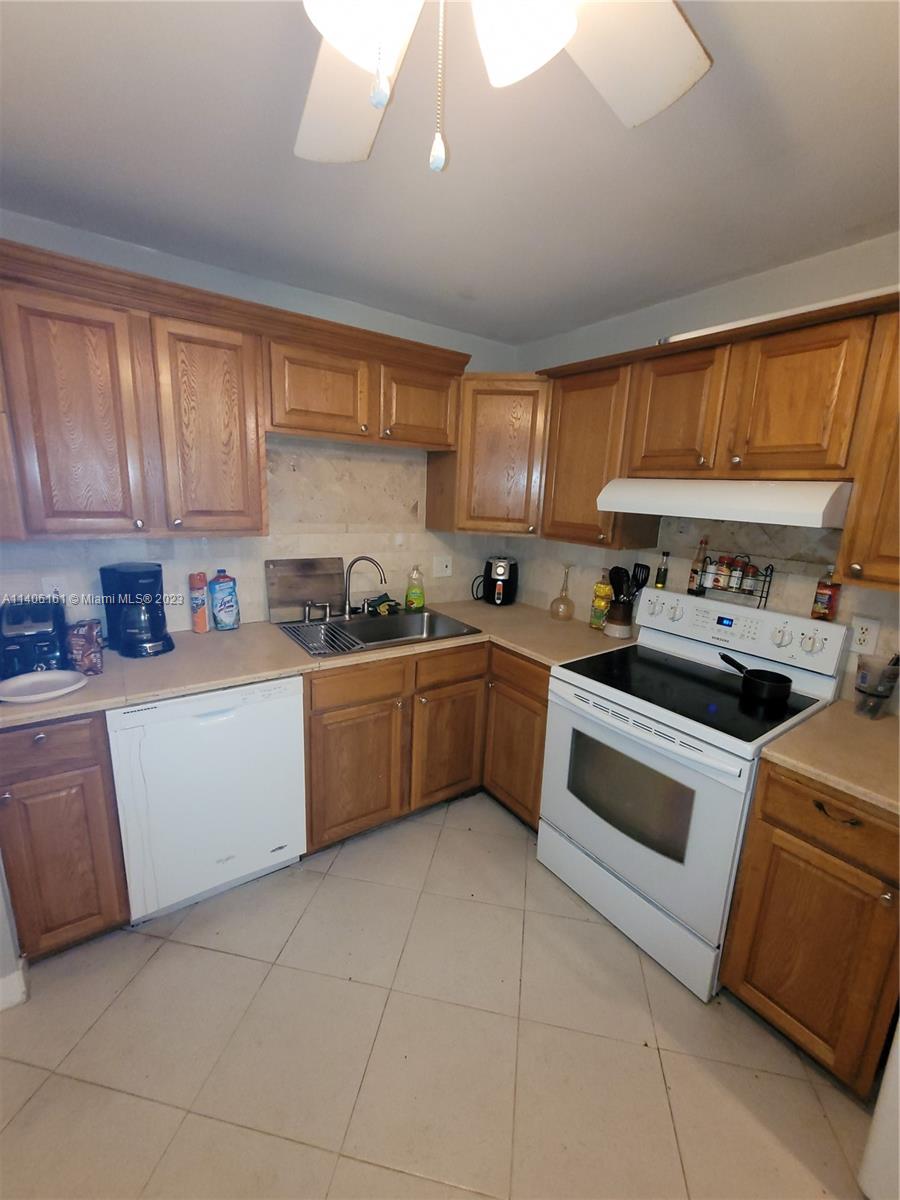 22605 Southwest 66th Avenue, Unit 207 Boca Raton, FL 33428 - Photo 12 of 15 a kitchen with a stove sink and cabinets