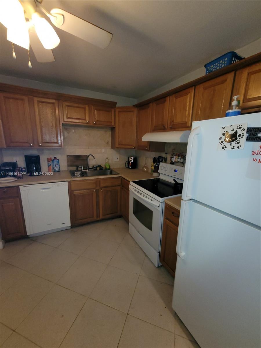22605 Southwest 66th Avenue, Unit 207 Boca Raton, FL 33428 - Photo 13 of 15 a kitchen with a sink a refrigerator and cabinets