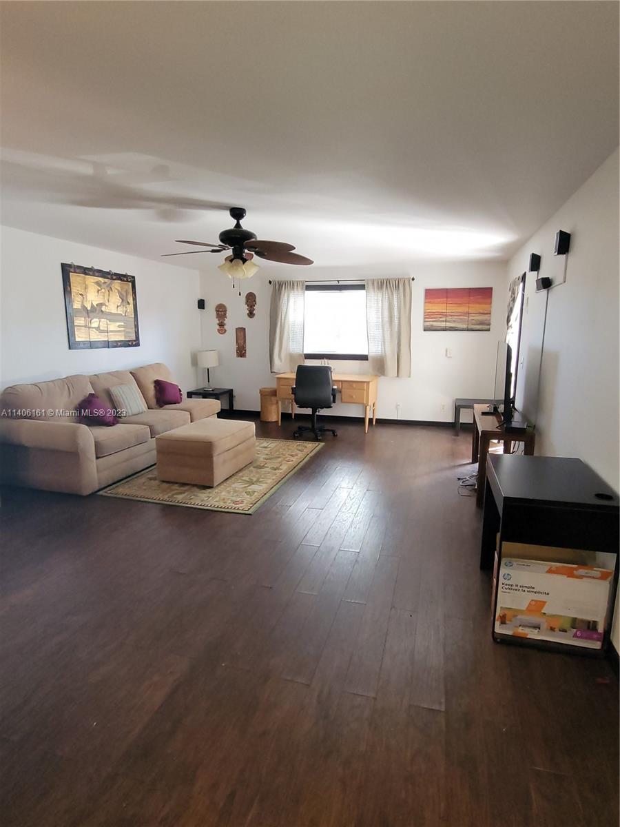 22605 Southwest 66th Avenue, Unit 207 Boca Raton, FL 33428 - Photo 14 of 15 a living room with furniture and a chandelier