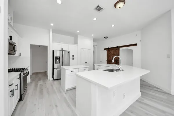 a kitchen with a sink appliances and cabinets