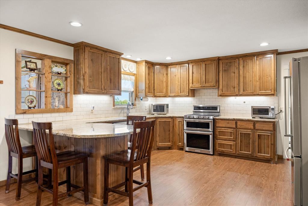 17305 Highway 281 Hico, TX 76457 - Photo 6 of 28 a kitchen with a table chairs a sink a window and stainless steel appliances