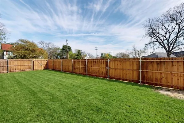 a view of a backyard with wooden fence
