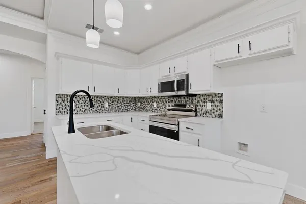 a kitchen with stainless steel appliances a sink a stove and cabinets