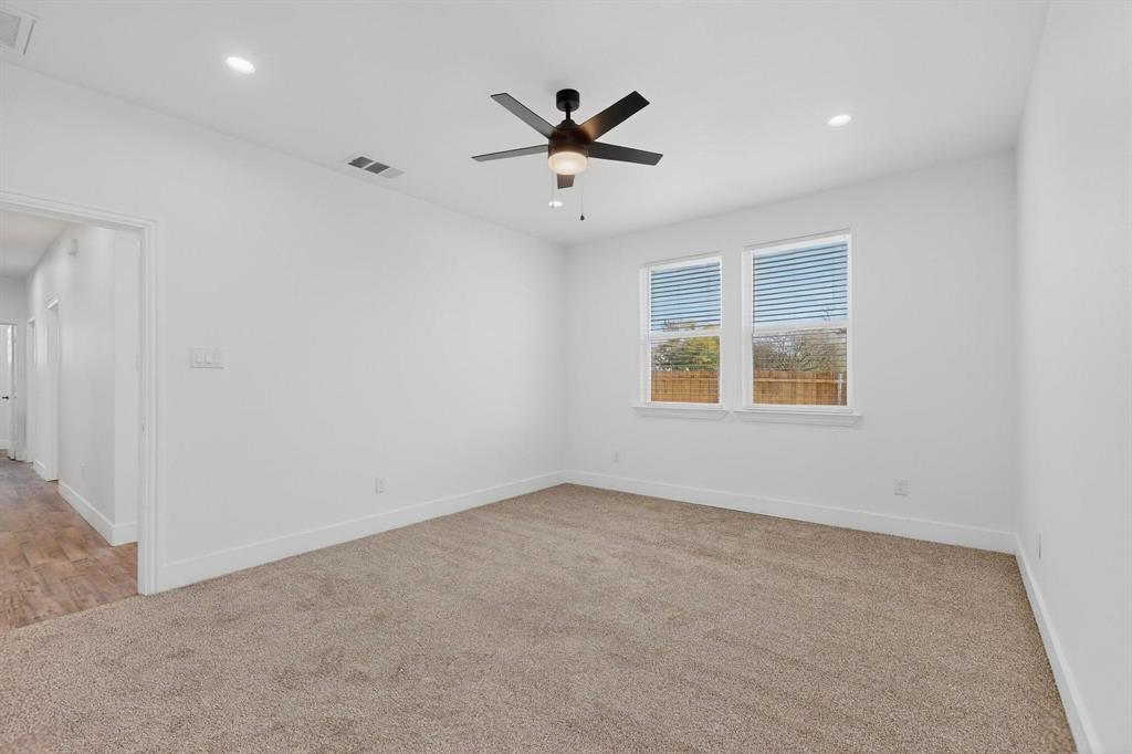 106 Jones Street Terrell, TX 75160 - Photo 9 of 26 an empty room with a ceiling fan and windows