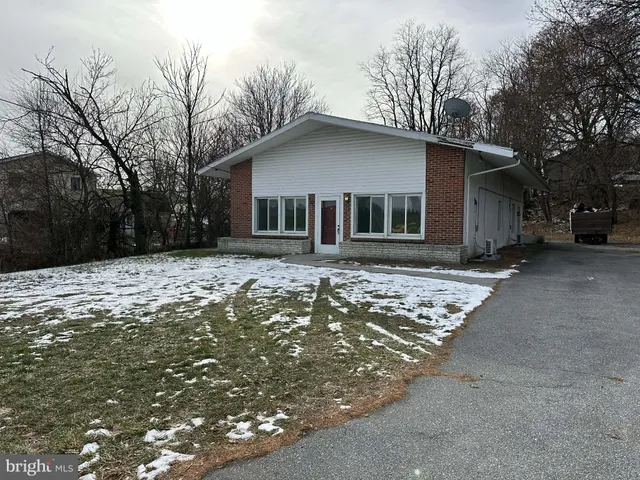 a front view of house with yard and trees