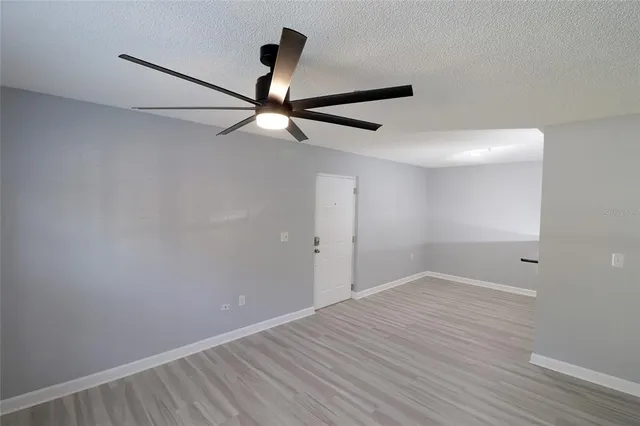 a view of an empty room with wooden floor