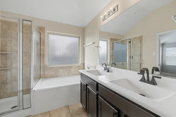 a bathroom with a tub a sink and mirror