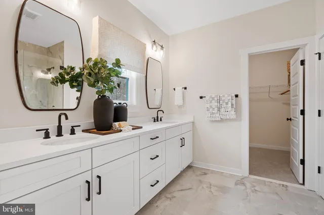 a bathroom with a double vanity sink mirror and shower