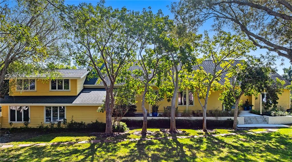 586 Yucca Road Naples, FL 34102 - Photo 3 of 26 Back of property featuring a yard and a shingled roof