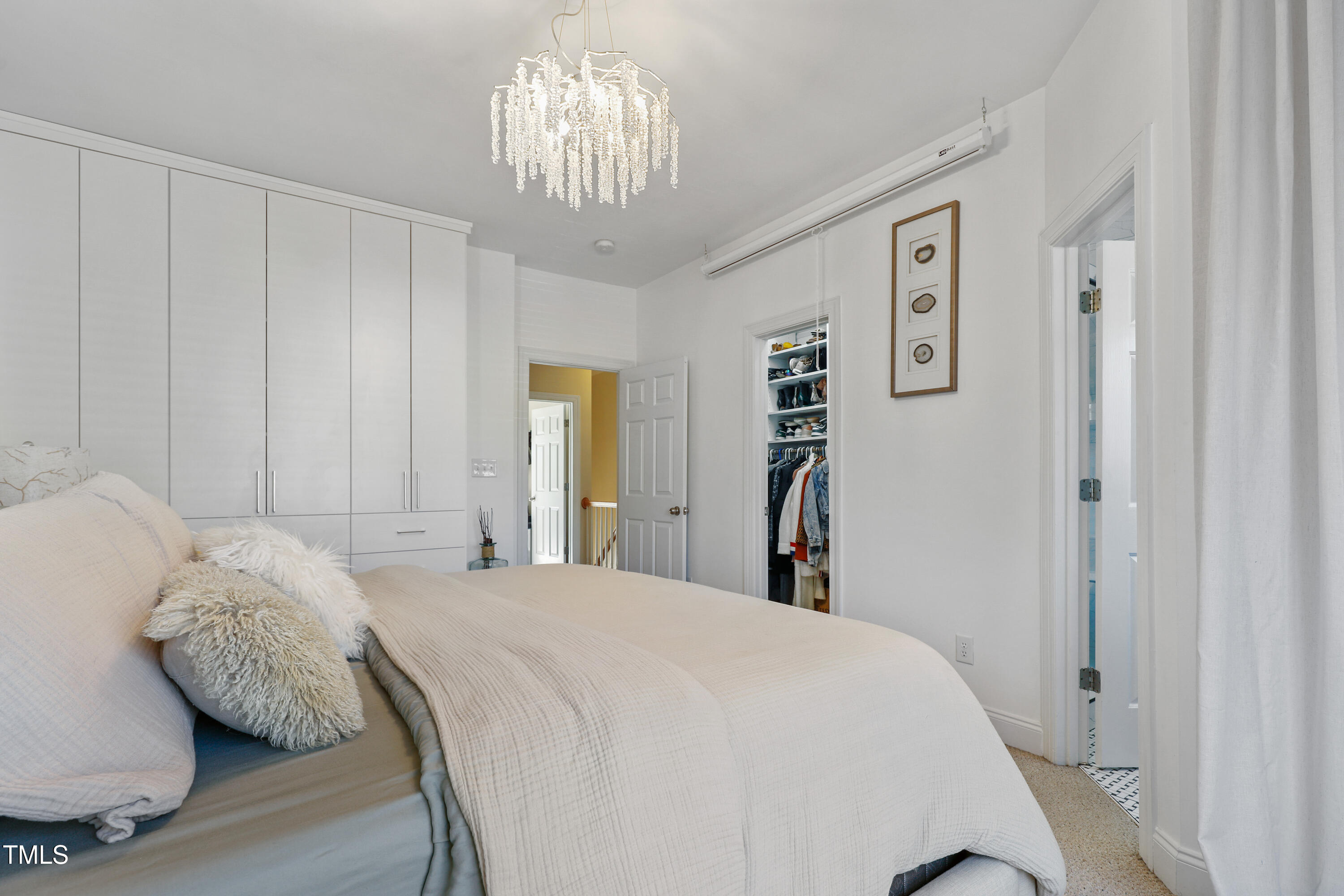 672 Highpark Lane Raleigh, NC 27608 - Photo 16 of 25 a bedroom with a large bed and a chandelier