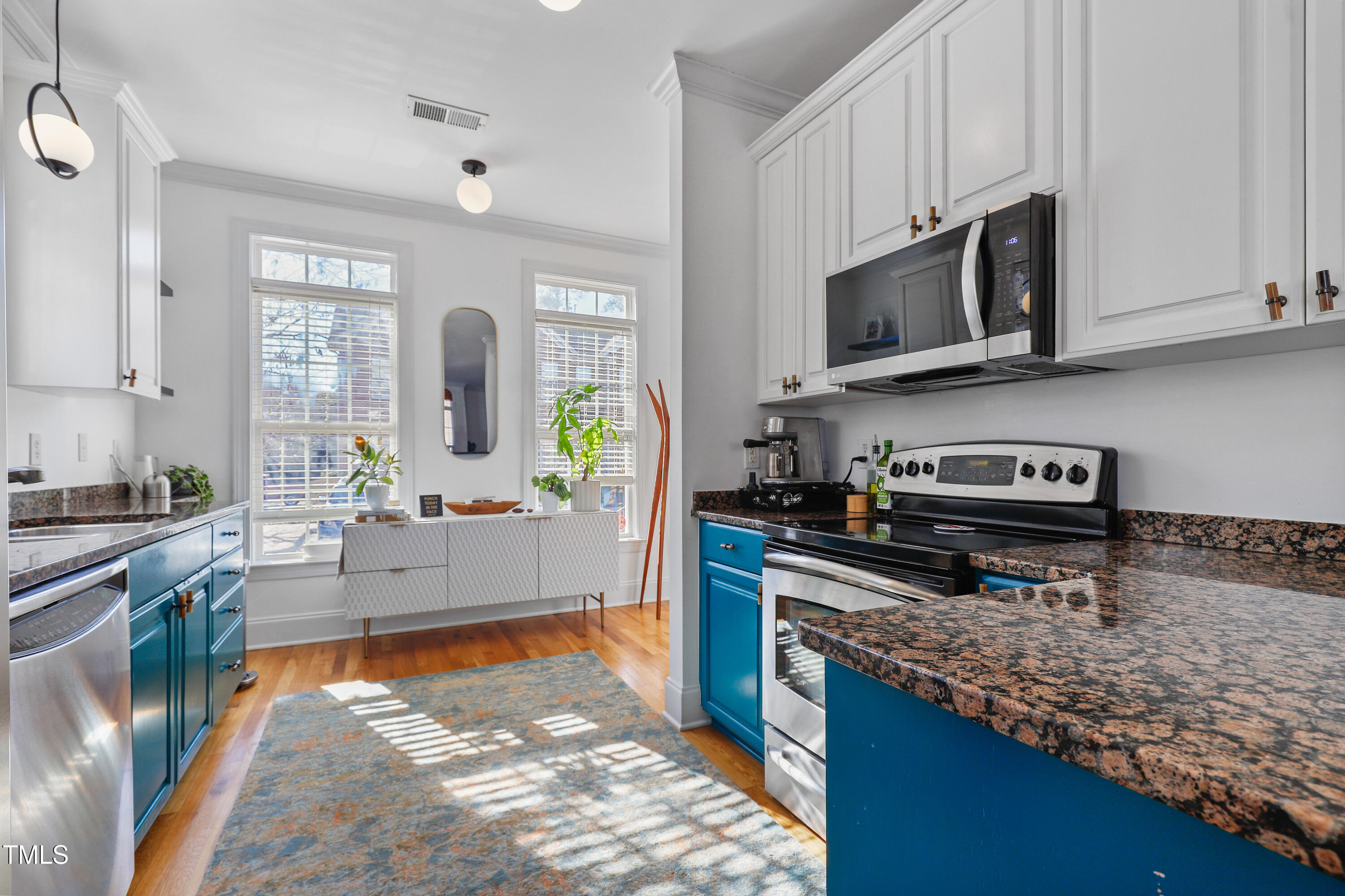672 Highpark Lane Raleigh, NC 27608 - Photo 7 of 25 a kitchen with stainless steel appliances granite countertop a stove a sink and a microwave