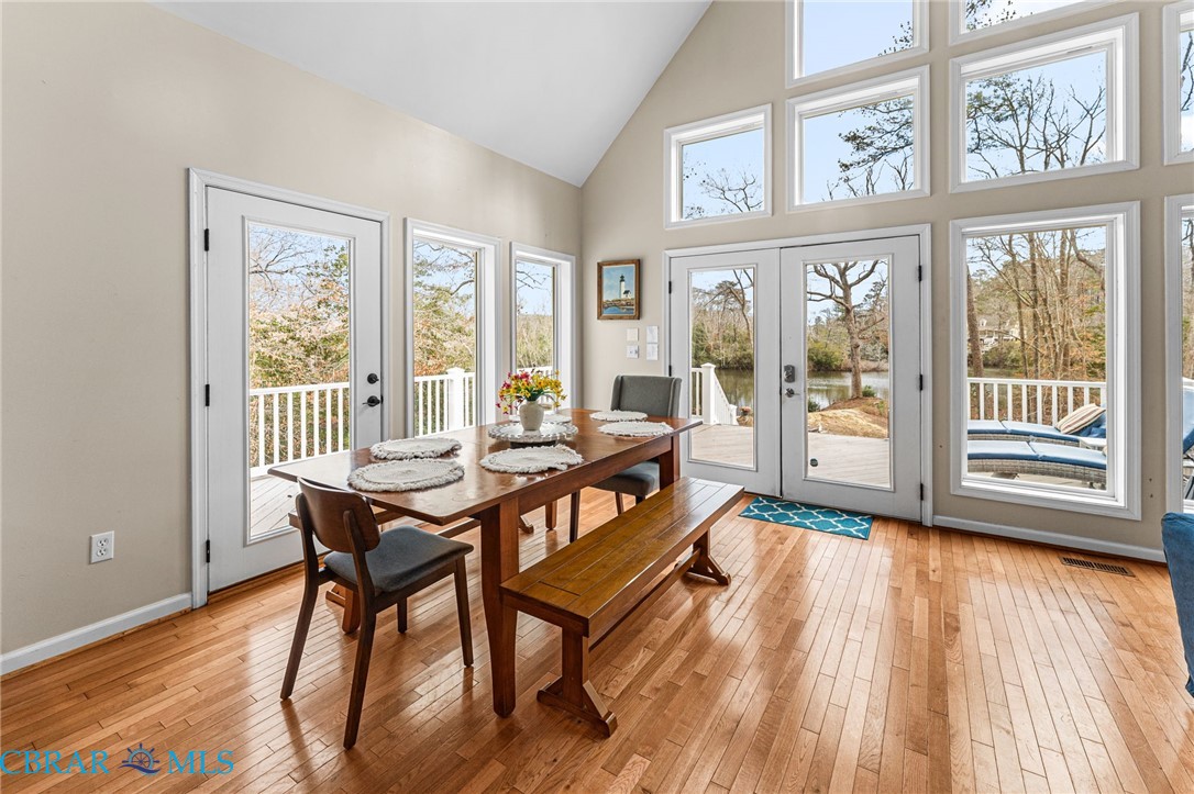 4775 Stormont Road Hartfield, VA 23071 - Photo 22 of 45 Dining space featuring french doors, light wood-type flooring, and vaulted ceiling