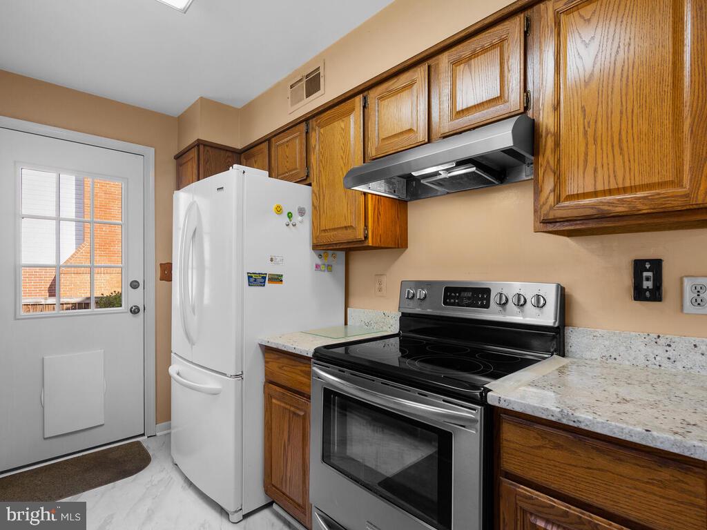 12714 Teaberry Road Silver Spring, MD 20906 - Photo 11 of 30 a kitchen with stainless steel appliances granite countertop cabinets and a refrigerator