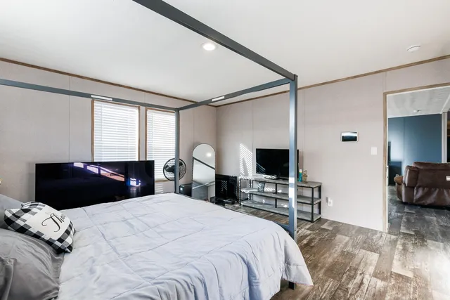 a bedroom with a bed and a flat screen tv