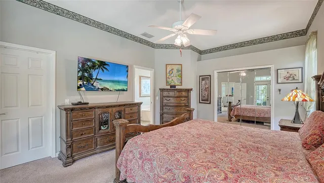 a bedroom with a large bed and a chandelier