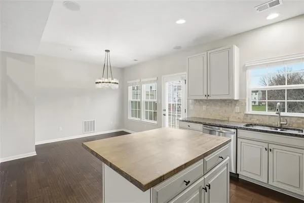 a kitchen with a stove a sink a center island and cabinets