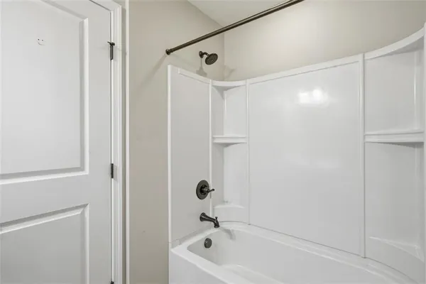 a bathroom with a tub shower and a sink