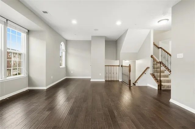 a kitchen with stainless steel appliances granite countertop a refrigerator a sink a stove a dining table and chairs