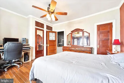 a bedroom with a bed a flat screen tv and a large mirror