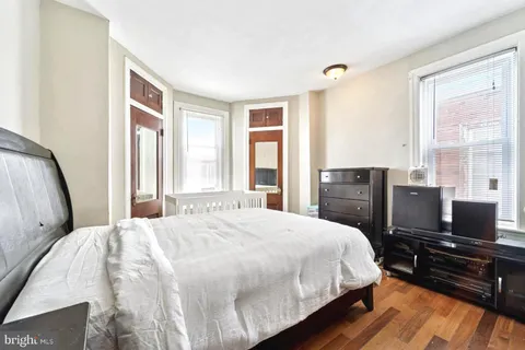 a bedroom with a bed and wooden floor