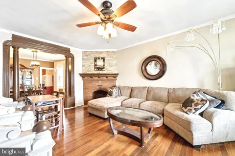 a living room with furniture a clock and a large window