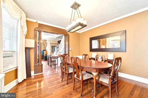 a dining room with furniture a chandelier and wooden floor
