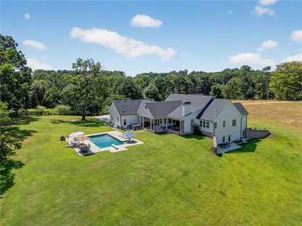 an aerial view of a house with swimming pool and garden