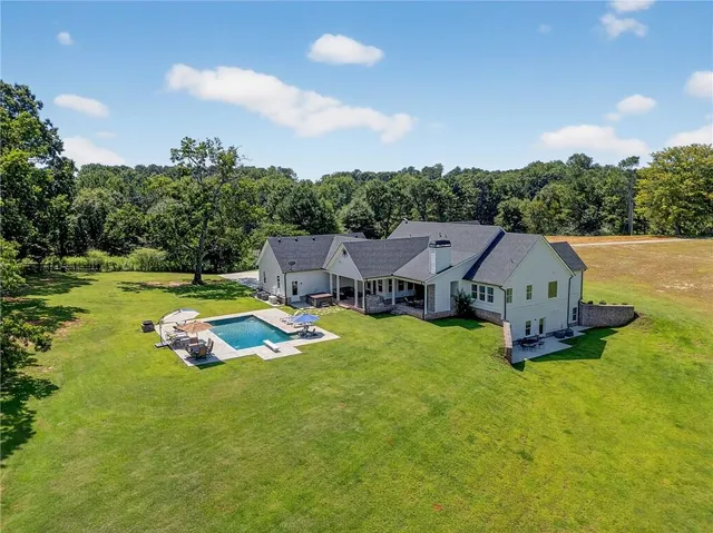 an aerial view of a house with swimming pool and garden