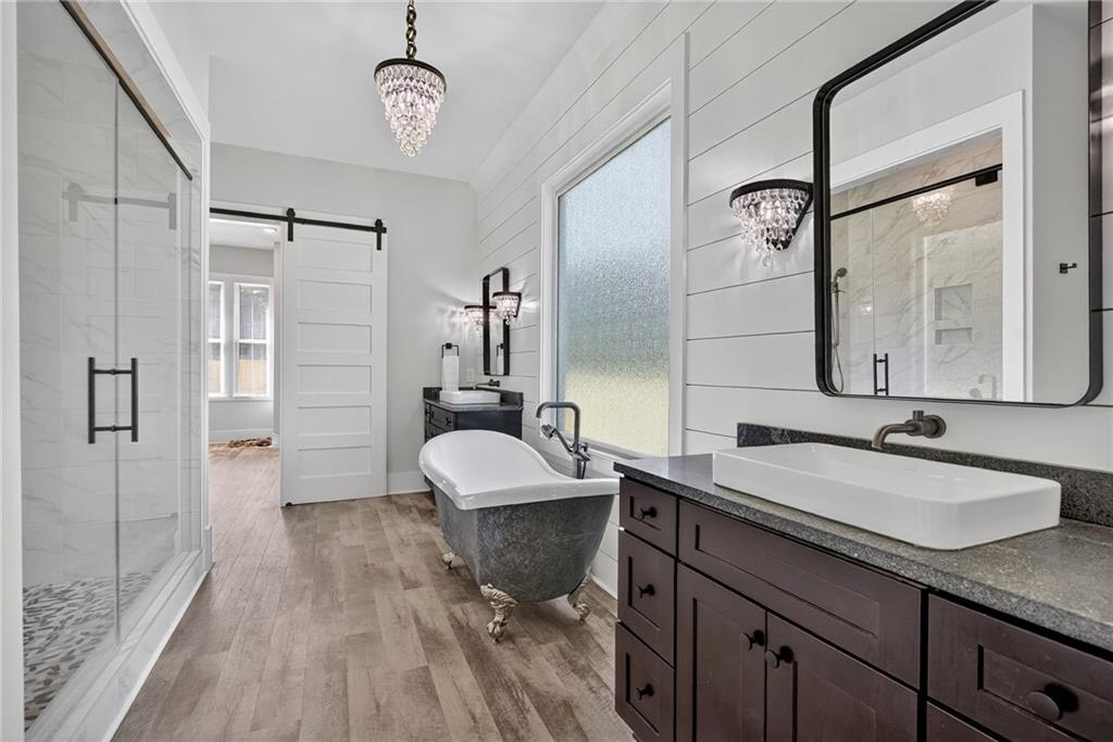4621 Stanley Road Flowery Branch, GA 30542 - Photo 26 of 65 a spacious bathroom with a granite countertop sink a mirror a toilet and a shower
