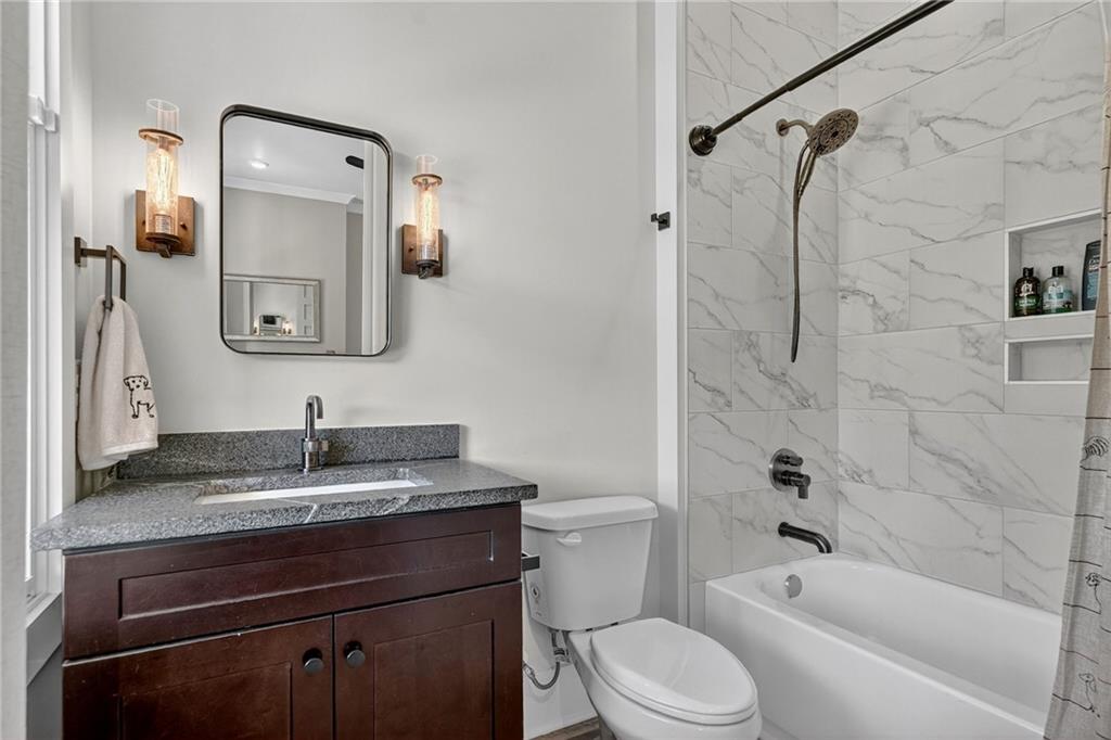 4621 Stanley Road Flowery Branch, GA 30542 - Photo 33 of 65 a bathroom with a granite countertop sink toilet and shower