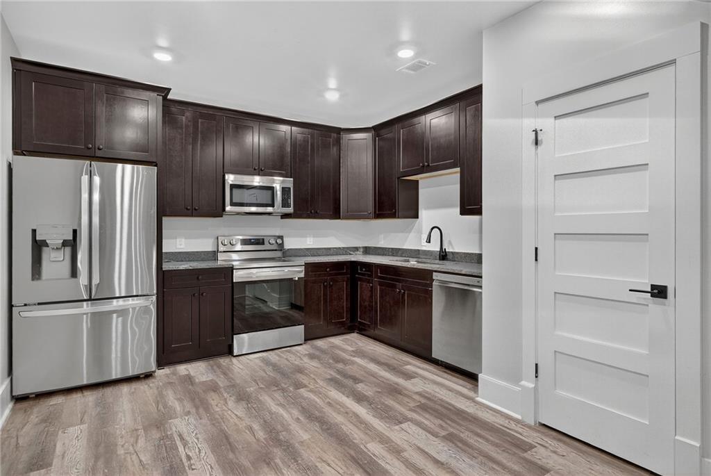 4621 Stanley Road Flowery Branch, GA 30542 - Photo 40 of 65 a kitchen with granite countertop stainless steel appliances and refrigerator