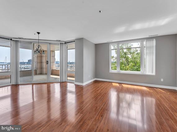 100 Harborview Drive, Unit 202 Baltimore, MD 21230 - Photo 18 of 25 a view of an empty room with wooden floor and a window